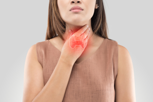 woman touching throat feeling thyroid glands